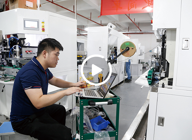 Worker using laptop near plug crimping machine